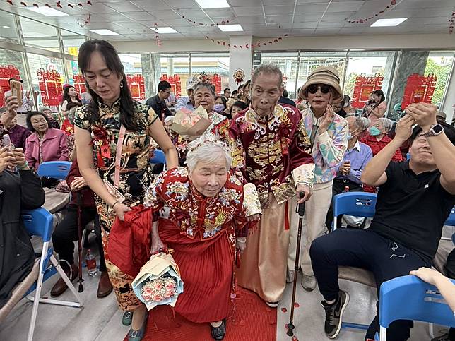 阿公阿嬤牽手走紅地毯進場，受到眾人熱烈祝福。(記者吳東興攝)