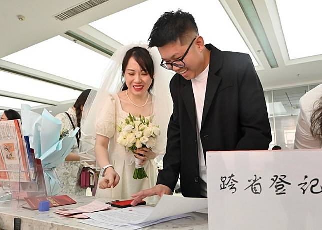 一對新人在跨省登記窗口登記結婚。（中新社圖片）