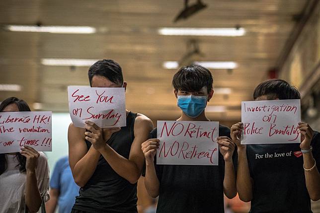Young activists hold up posters with messages supporting the protest movement and informing passers-by about upcoming events, in Hong Kong on August 20. Photo: EPA-EFE