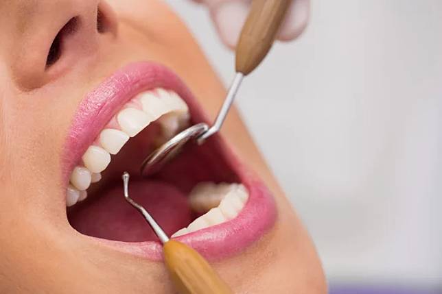 dentist-examining-female-patient-teeth_107420-65309