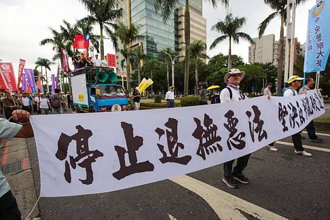 2018年4月24日，退休警消人員24日舉行警消不服從遊行，並手持「停止退撫惡法，堅決反對亂砍退休金」標語。（資料照，顏麟宇攝）