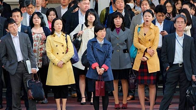 東京早上高峰期間，上班通勤者正等待過馬路。美聯社