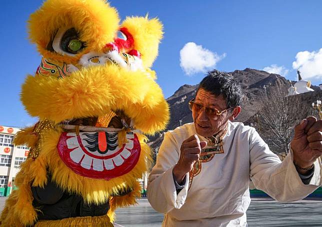 Tengpa Anye ® instructs students to perform lion dance at a primary school in Xobando Town of Lhorong County in Qamdo City, southwest China's Xizang Autonomous Region, Jan. 19, 2024. (Xinhua/Sun Fei)