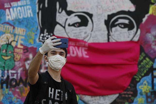 The ‘Lennon Wall’ with a face mask attached in Prague. The Czech government said Monday it would ease its tough anti-virus measures ahead of Easter. Photo: AP