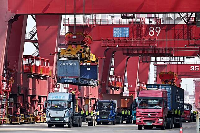 Trucks transport containers at Qingdao Port in east China's Shandong Province, March 13, 2024. (Xinhua/Li Ziheng)