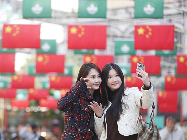 People pose for photos at the Senado Square in south China's Macao, Dec. 20, 2024. Friday marks the 25th anniversary of Macao's return to the motherland. (Xinhua/Yao Qilin)