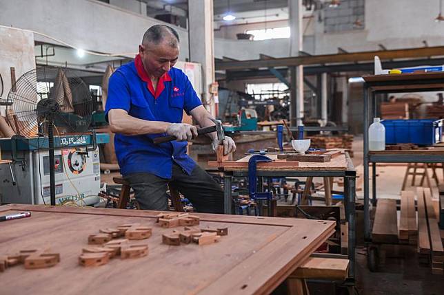 An employee works at a furniture plant in Huayuan Village of Nanma Town, Dongyang City, east China's Zhejiang Province, June 19, 2023. (Xinhua/Xu Yu)