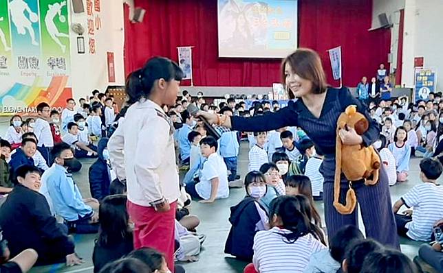 犯罪矯正協會「仙女姐姐」律師梁家瑜（右），在永信國小法治教育活動中與台下學童互動進行法律有獎徵答，學童們搶答踴躍。　（記者汪惠松攝）