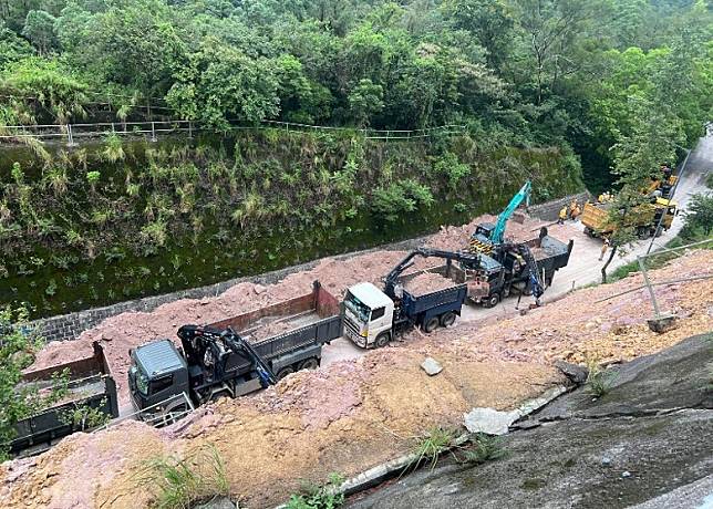 新娘潭路山坡的護土牆坍塌，工程人員清理現場。