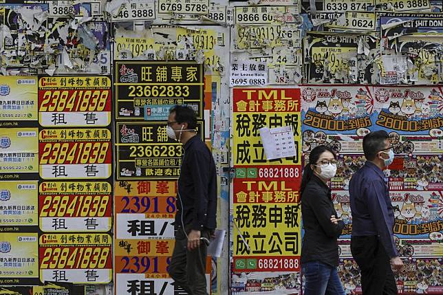 People wearing protective masks walking past a shuttered shop in Causeway Bay on March 16, 2020, following the outbreak of the new coronavirus. Photo: Sam Tsang