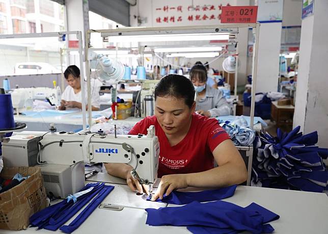 Residents work at a garment workshop at a relocation site in Huanjiang Maonan Autonomous County, south China's Guangxi Zhuang Autonomous Region, Aug. 30, 2024. (Xinhua/Jin Haoyuan)