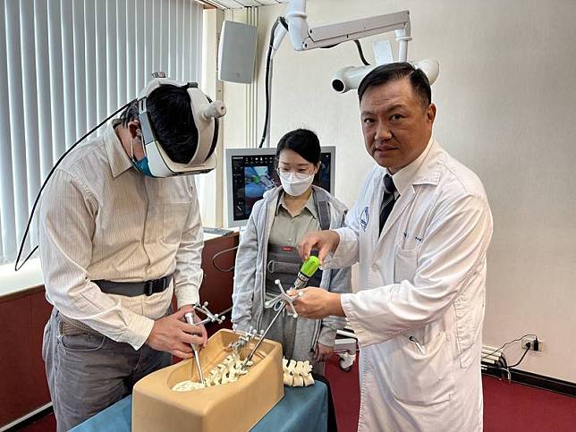 台中榮總神經外科主任楊孟寅（右）1日表示，在脊椎側彎矯正手術過程中，先進行3D掃描獲得即時脊椎影像，再搭配AR眼鏡及術中導航系統，使脊椎側彎3D影像能立即投射在病患身上，呈現於醫師眼前，讓醫師在手術中能有效避開危險區域。 中央社記者郝雪卿攝 111年12月1日  
