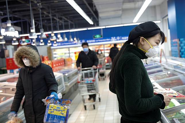 People in protective face masks in a Beijing supermarket on February 19, 2020. The public health crisis could be a long-term growth catalyst for supermarket chains that have integrated online and offline channels. Photo: Reuters