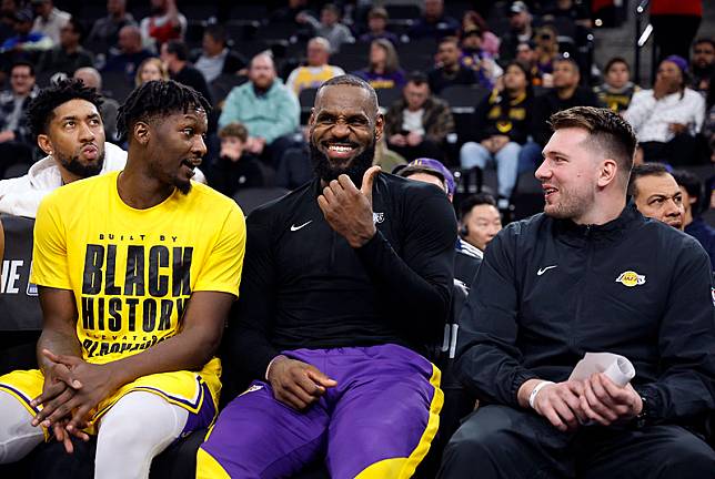 被獨行俠送至籃網又在去年底轉戰湖人的Dorian Finney-Smith、LeBron James、Luka Dončić在湖人板凳相談甚歡。（達志影像）