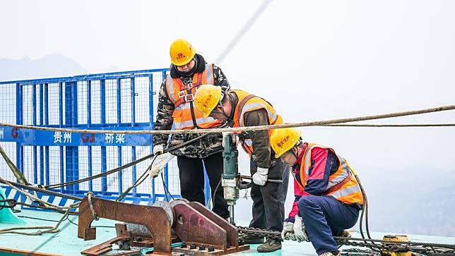 Workers operate at the construction site of the Huajiang Grand Canyon Bridge in southwest China's Guizhou Province, Jan. 17, 2025. (Xinhua/Tao Liang)