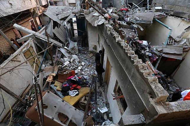 People are seen on the rubble of a house destroyed in an Israeli airstrike in al-Nuseirat refugee camp, central Gaza Strip, on Dec. 16, 2024. (Photo by Rizek Abdeljawad/Xinhua)