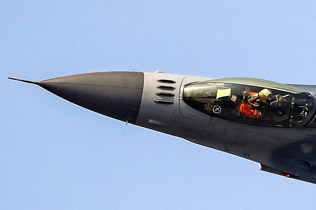 F-16戰機的單機特技教官林暄期，今天在台南基地進行飛行性能展示，在戰機低飛側轉時，還能單手比出21作戰隊的手勢，向全場數萬觀眾致意。(圖：取自青年日報臉書專頁)