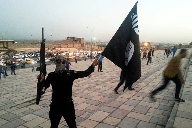 2014年在摩蘇爾高舉旗幟的「伊斯蘭國」支持者。（湯森路透）
