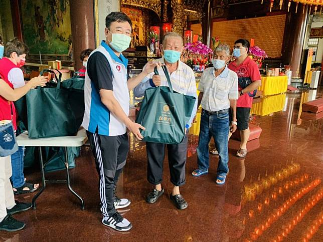 市議員吳禹寰（左）代表保華宮轉贈中元供品及白米給弱勢族群。（記者黃文記攝）