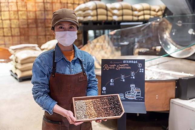 A staff member shows samples of raw and roasted coffee beans at the Starbucks Reserve Roastery in east China's Shanghai, Nov. 24, 2023. (Xinhua/Wang Xiang)