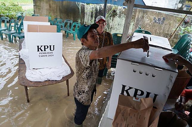 A man votes at a polling station in flood water in Tanjung Gusta village of North Sumatra Province, Indonesia, Nov. 27, 2024. (Photo by Irsan Mulyadi/Xinhua)