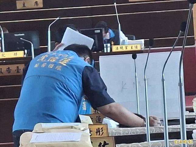 台中市議員沈佑蓮(右，背對鏡頭坐者)質詢完後在座位上狂吐，助理急忙遞衛生紙。(記者蘇金鳳攝)