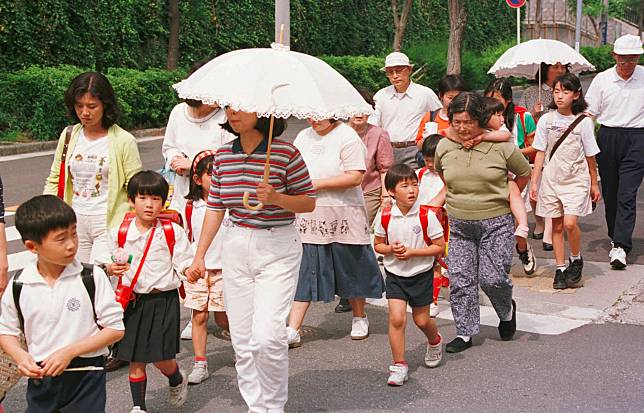 1997年6月10日，在日本的神戶，由於連續兒童殺傷事件的兇手當時仍未被逮捕，家長和老師每天分組陪同孩子上下學。（攝影／AP Photo／Koji Sasahara／達志影像）