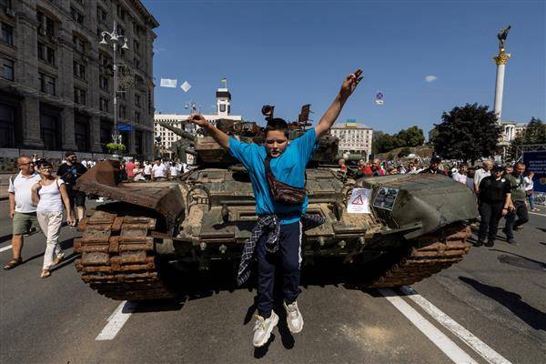 烏克蘭為迎接8月24日獨立日，在首都基輔展示被摧毀的俄軍坦克。圖中男童週日（8/21）自展示的坦克跳下玩耍。路透社
