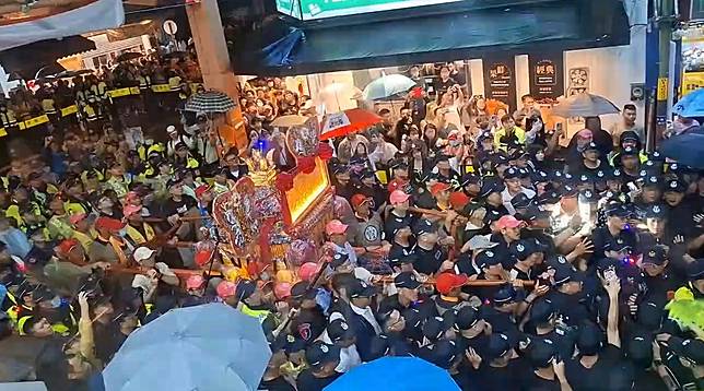 大甲媽祖鑾轎回鑾，24日晚間準備前往天后宮駐駕前，爆發一群黑衣人試圖搶扶娘傘，警方強制推開人群，化解衝突。Threads網友授權