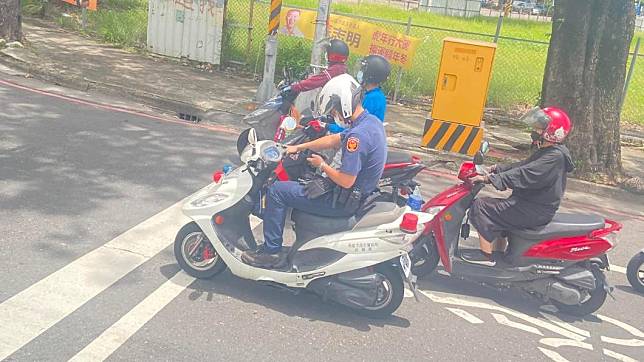 一名員警疑似在等紅燈時滑手機。（圖／翻攝自爆廢公社公開版）