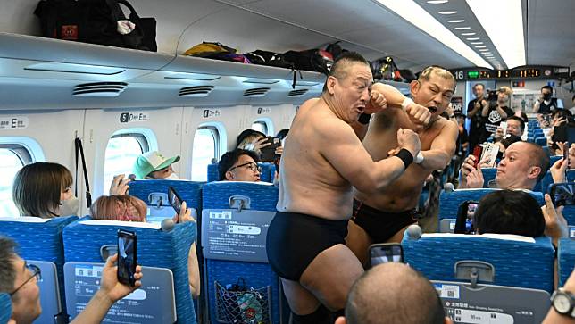 為推廣摔角，日本摔角選手鈴木實（後）與高木三四郎（前），18日在日本新幹線車廂內對打。路透社