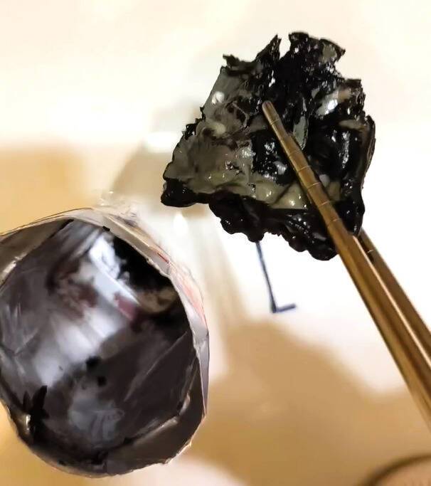 民眾摸到鋁箔包裝有硬物，剪開包裝發現一大團黑色異物。(陳先生提供)