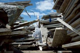 嘉義新塭滯洪池光電場在丹娜絲風災中受到重創，3萬多片的廢棄光電板從水中打撈上岸後暫置在臨時租用的土地上等待清運。照片拍攝於8月上旬。（攝影／謝佩穎）