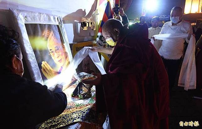 在台藏人福利協會今晚在台北自由廣場舉行「世界和平祈福點燈法會：310西藏抗暴日62週年晚會」，格爾登仁波切(中)向達賴喇嘛肖像獻上哈達。(記者廖振輝攝)