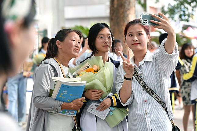 A student and family members pose for a photo at a national college entrance examination site in Shijiazhuang, north China's Hebei Province, June 9, 2024. (Photo by Zhang Xiaofeng/Xinhua)