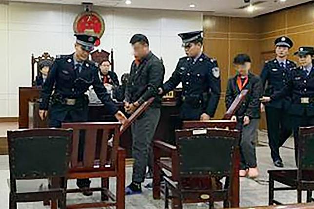 Xiao and Wang are led into the Shunyi District People’s Court in Beijing on December 26. The pair have been jailed for eight months. Photo: Weibo