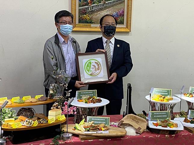 農糧署糧食產業組組長林傳琦（左）頒授「臺灣米標章」認證證書給中華醫大餐旅系健康樂活餐廳，由校長孫逸民（右）代表接受