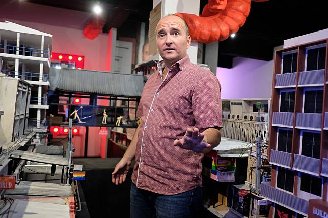 Michael Messner, owner and curator of Patpong Museum, shows off a miniature model of a Patpong street complete with go-go bar and dancers. Photo: Tibor Krausz