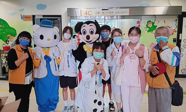 重症兒童關懷協會理事長蔡雅惠（左）帶領幹部和志工們，把兒童節禮物送到成大醫院兒童病房。（重症兒童關懷協會提供）