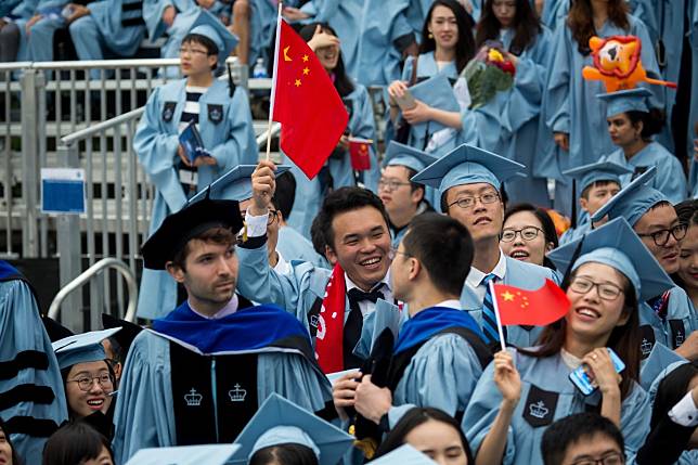 Graduates at Columbia University in New York wave Chinese national flags. Photo: Xinhua