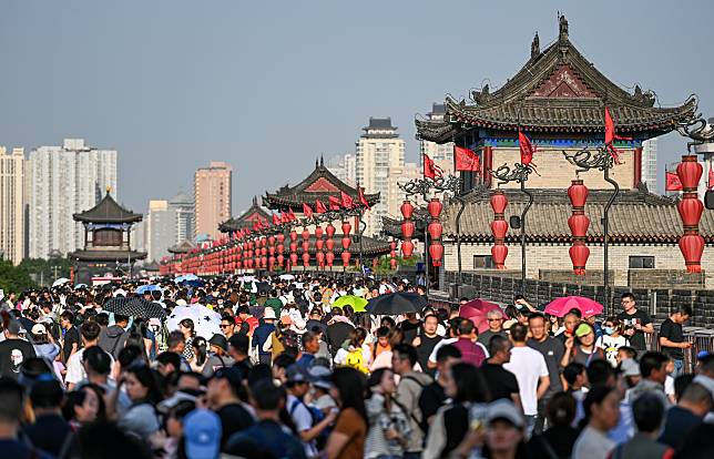 People visit the ancient city wall scenic spot in Xi'an, northwest China's Shaanxi Province, April 30, 2023. China has witnessed a travel boom during this year's five-day May Day holiday. (Photo by Zou Jingyi/Xinhua)