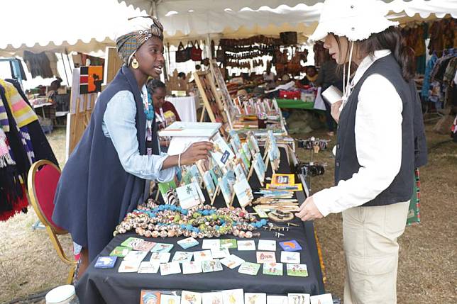 An exhibitor (L) displays goods made from recycled materials during the Magical Kenya Travel Expo in Nairobi, capital of Kenya, Oct. 3, 2024. (Photo by Allan Mutiso/Xinhua)