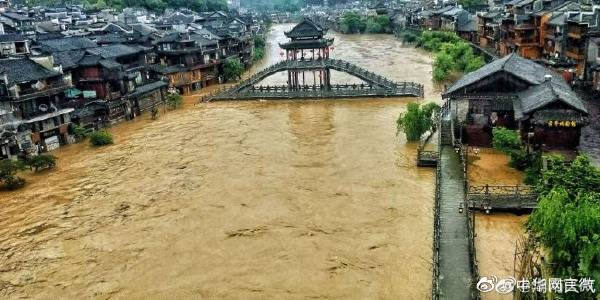 受暴雨影響，湖南鳳凰縣沱江水位上漲，橫跨沱江的古橋遭水淹沒。   圖：翻攝自微博