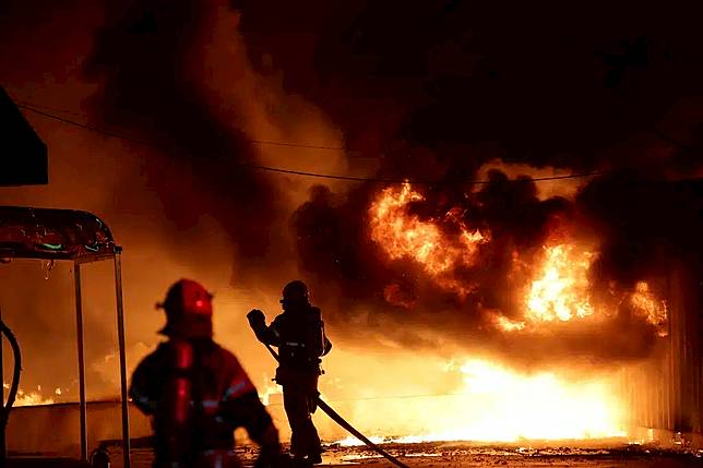 Firefighters extinguish a fire at a factory building that has been engulfed in a wildfire in Uiseong, South Korea, Saturday, March 22, 2025. (Yoon Gwan-shick/Yonhap via AP)
