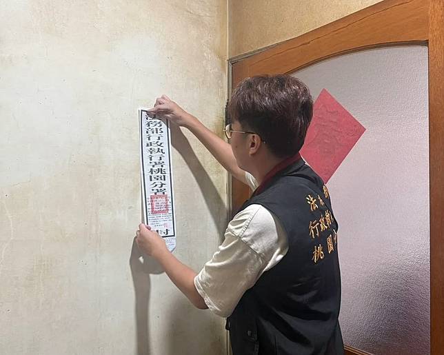 執行人員貼封條。桃園分署提供