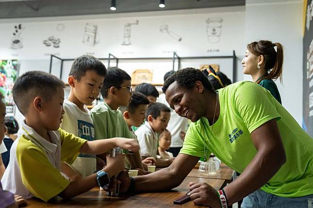 A volunteer grinds coffee beans with children during a hands-on experience session at the Ethiopia pavilion of a permanent exhibition hall of the China-Africa Economic and Trade Cooperation Promotion Innovation Demonstration Park in Changsha, central China's Hunan Province, Aug. 30, 2024. (Xinhua/Chen Sihan)