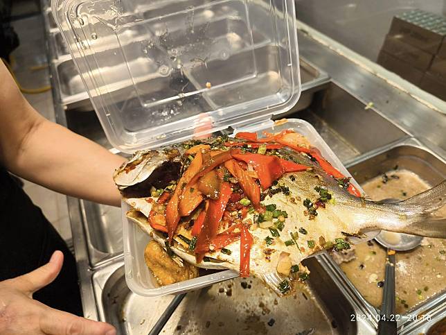 有網民分享在九龍灣一間兩餸飯店舖買外賣點了一條蒸魚，形容「大到個盒都放唔落」，售價只需50元，引起網民熱議。（「香港兩餸飯關注組」FB圖片）