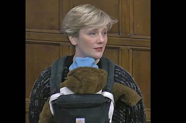 英國工黨議員克蕾西23日將三個月大的兒子揹在胸前，進入下議會進行辯論，卻遭批違反下議院規則。（AP）