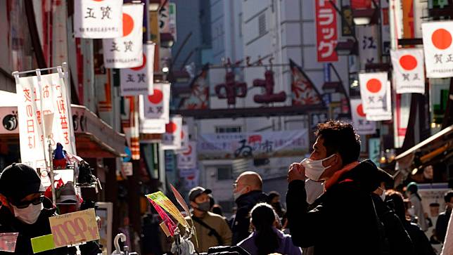 人們在東京的一條購物街漫步。美聯社