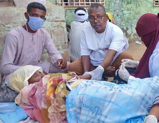 This photo taken via mobile phone on Feb. 22, 2025 shows doctors and paramedics providing medical assistance to a woman infected with cholera in Kosti city in White Nile State, Sudan. (Photo by Ahmed Idris/Xinhua)